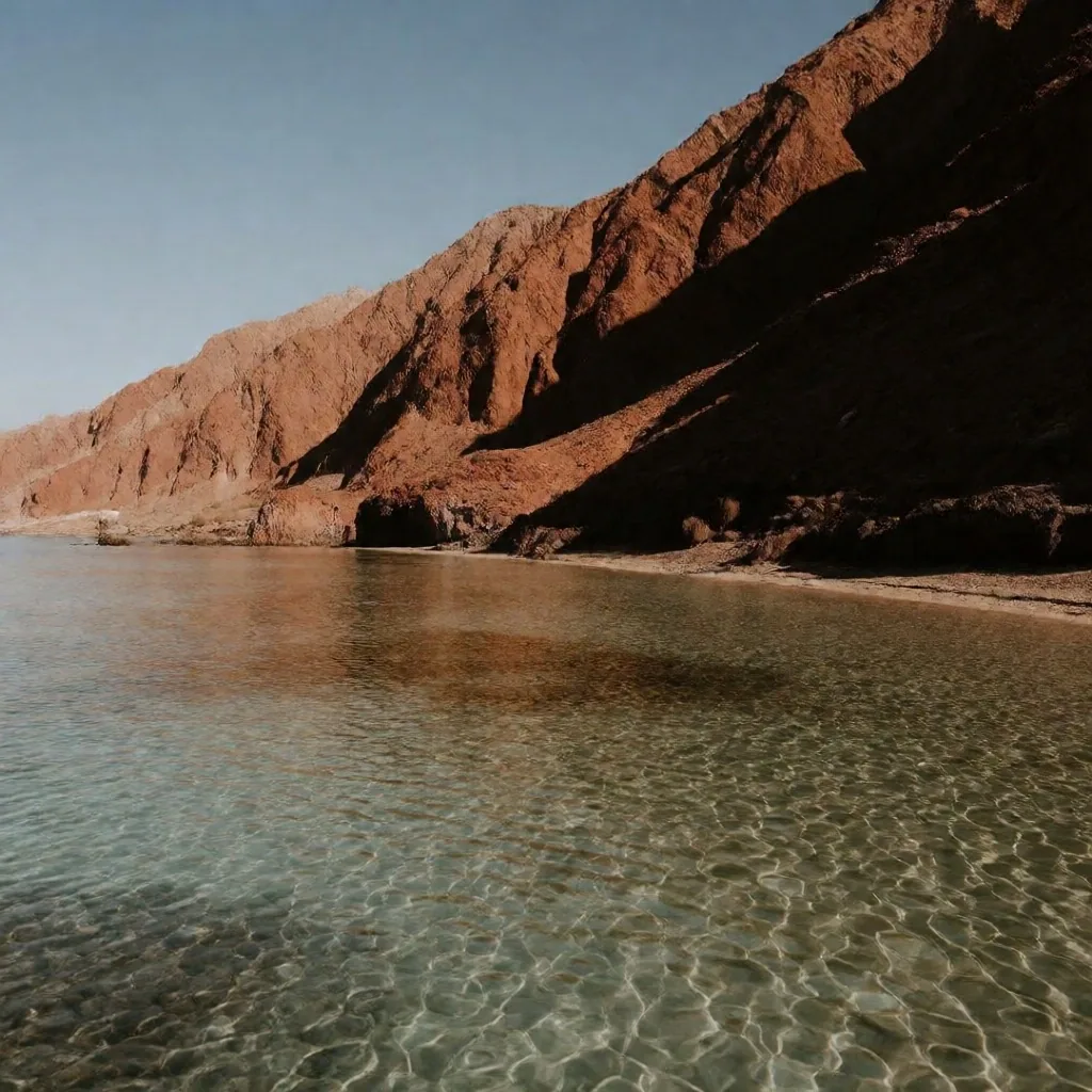 Red granite mountains meeting the Red Sea coast with clear turquoise water