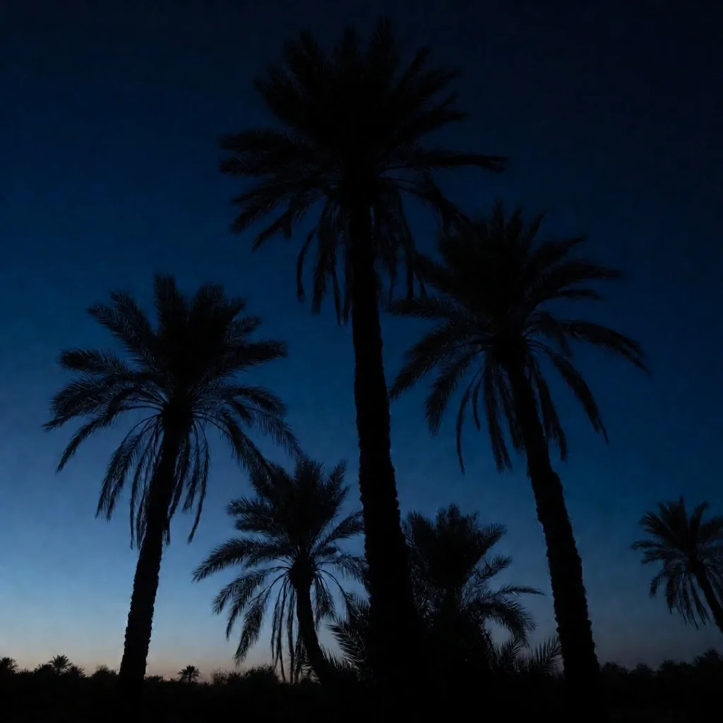Palm tree silhouettes against a deep blue twilight sky over the Egyptian desert